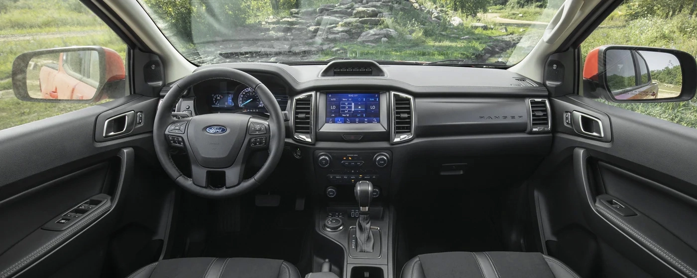 Interior view of a Ford truck cabin showing the steering wheel, touchscreen display, and dashboard