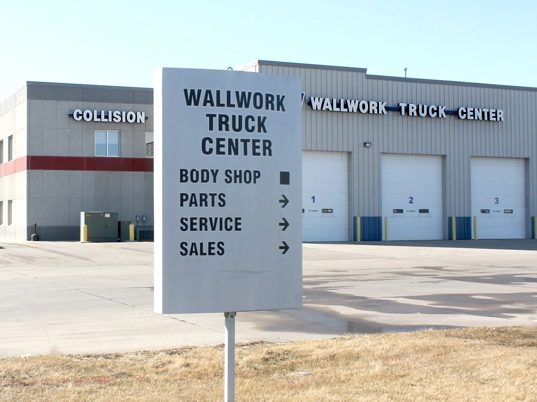 the sign of Wallwork Truck Center departments like parts, service and sales with the main building in the background